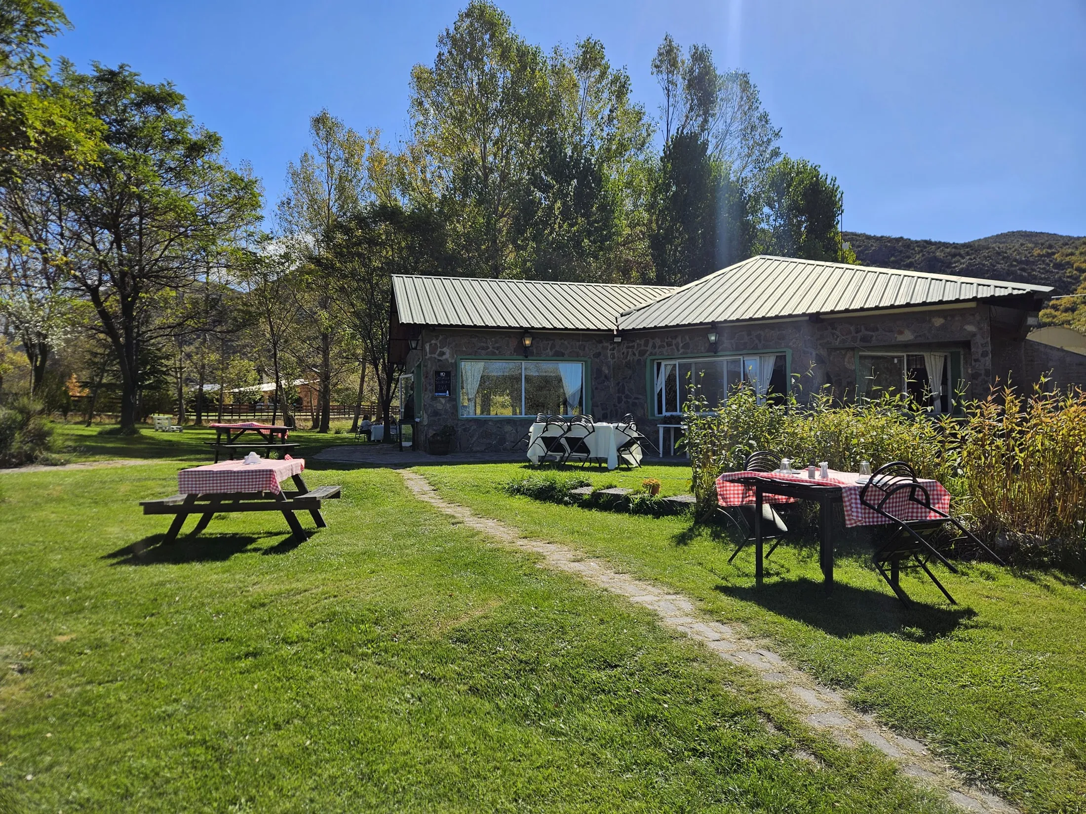 El jardín de la Posada del Manzano con la casa y la montaña de fondo